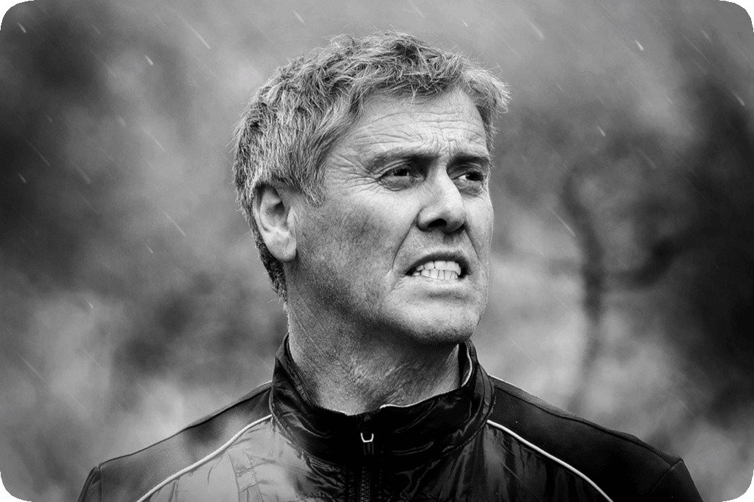 Picture of a man standing outside in the pouring rain.
