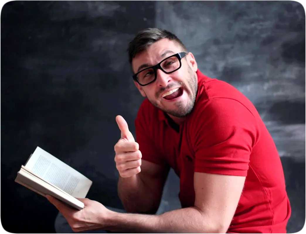 Picture of a man reading a book and giving a thumbs up gesture.