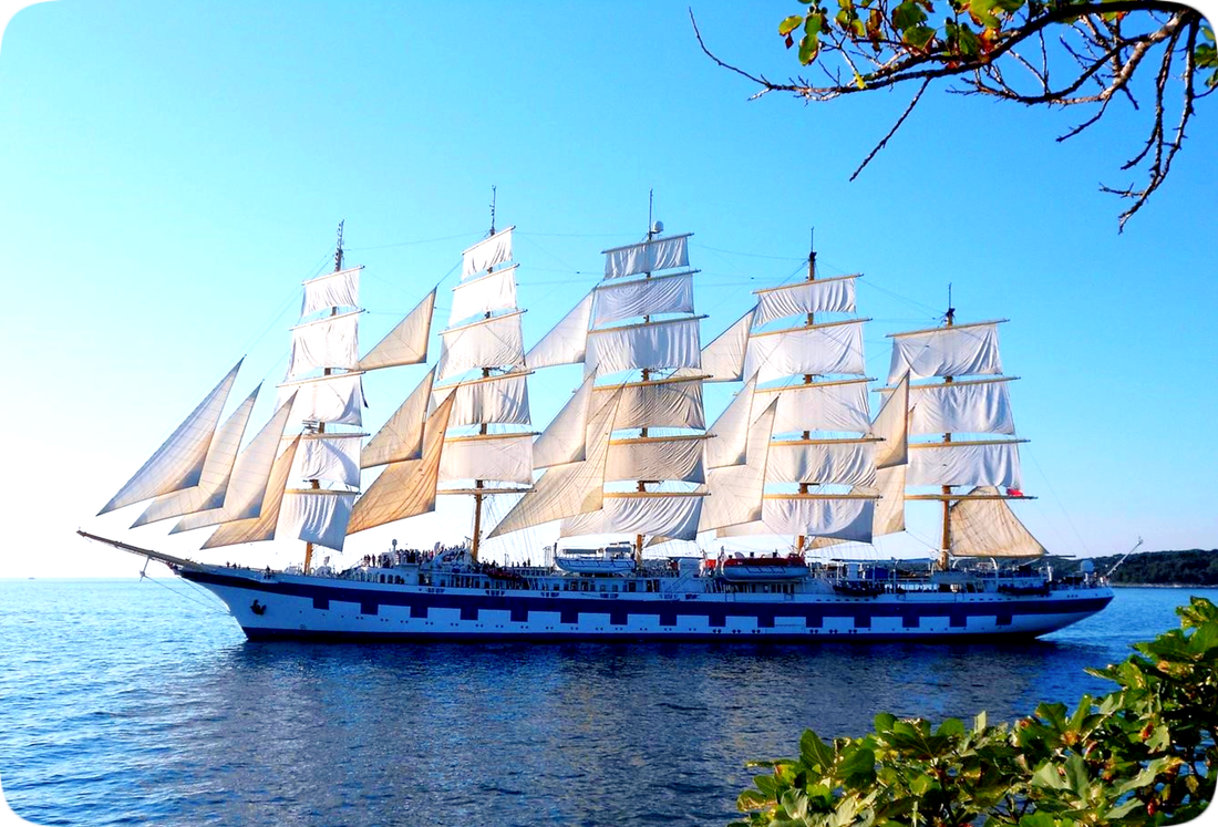 Picture of a 5-masted schooner, a type of sailing ship, close to shore.