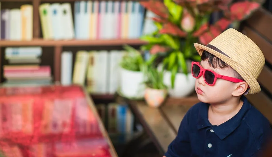 Picture of a boy wearing sunglasses indoors.