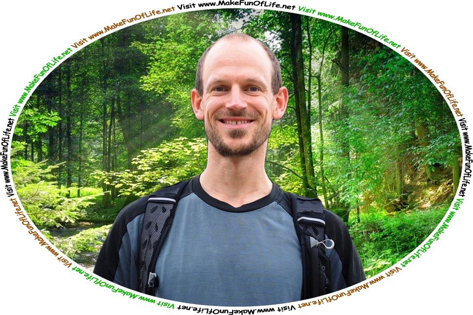 Picture of a happy smiling man standing among leafy green trees in a wilderness area, and the words, ‘Visit www.MakeFunOfLife.net.’