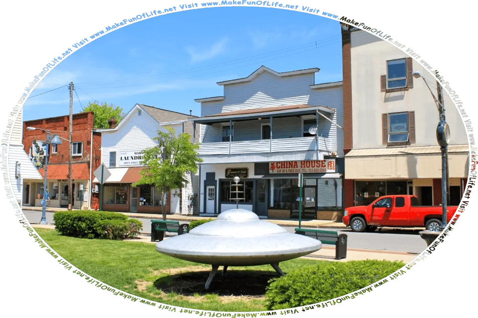 Picture of a human-made monument of a disc-shaped UFO, or Unidentified Flying Object, in a public park in Mars, Pennsylvania, United States of America, and the words, Visit www.MakeFunOfLife.net.