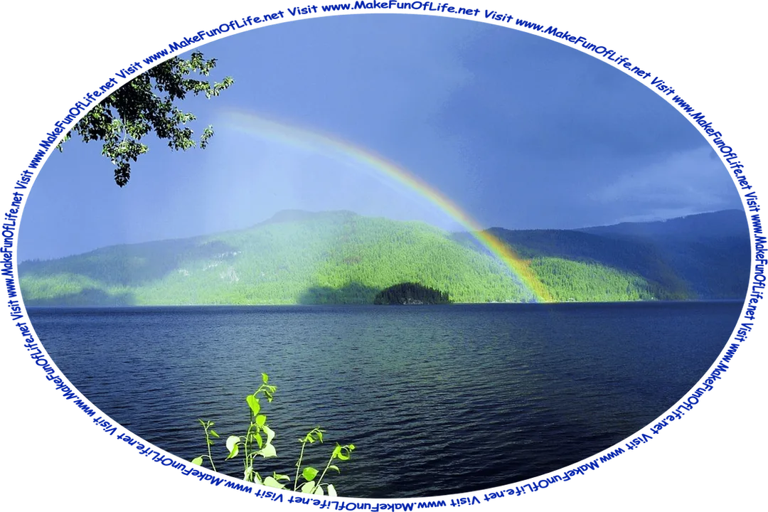 Picture of a rainbow at the edge of a lake, with tree-covered hills at the far edge of the lake, an overcast sky above, and the words, ‘Visit www.MakeFunOfLife.net.’