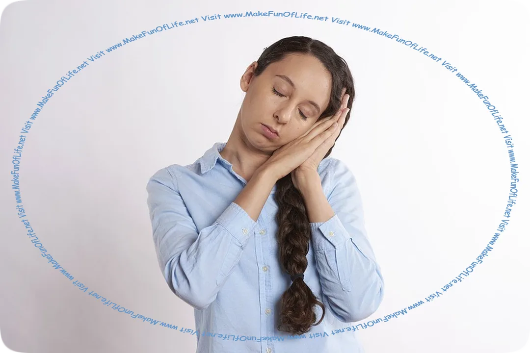 Picture of a woman miming, or doing an impression of a sleeping person, by standing with her eyes closed and her head tilted and resting on her hands held palm to palm. Indoor picture of a standing woman doing an impression of a sleeping person by holding the palms of her hands pressed flat together against the side of her slightly tilted head, with her eyes closed.