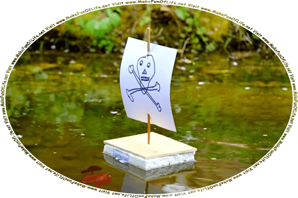 Picture of a pond, and floating in it, a toy pirate ship made from a block of wood and Styrofoam, with a thin wooden stick for a mast, a sheet of paper for a sail, with a hand-drawn skull and crossbones on the paper sail, and the words, Visit www.MakeFunOfLife.net.