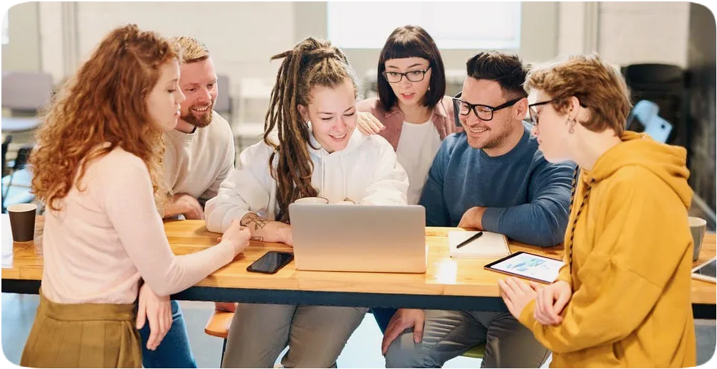 Picture of six students gathered around a computer.
