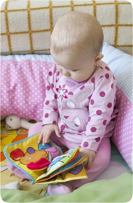 Picture of an infant looking at a picture book.